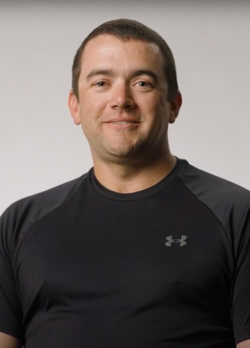 A headshot of a man in a black Under Armour shirt